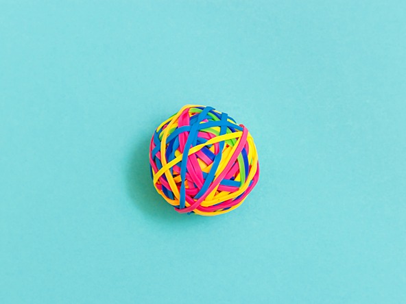 ball of coloured elastic bands against a light blue background