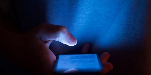 person using smartphone in a dark room